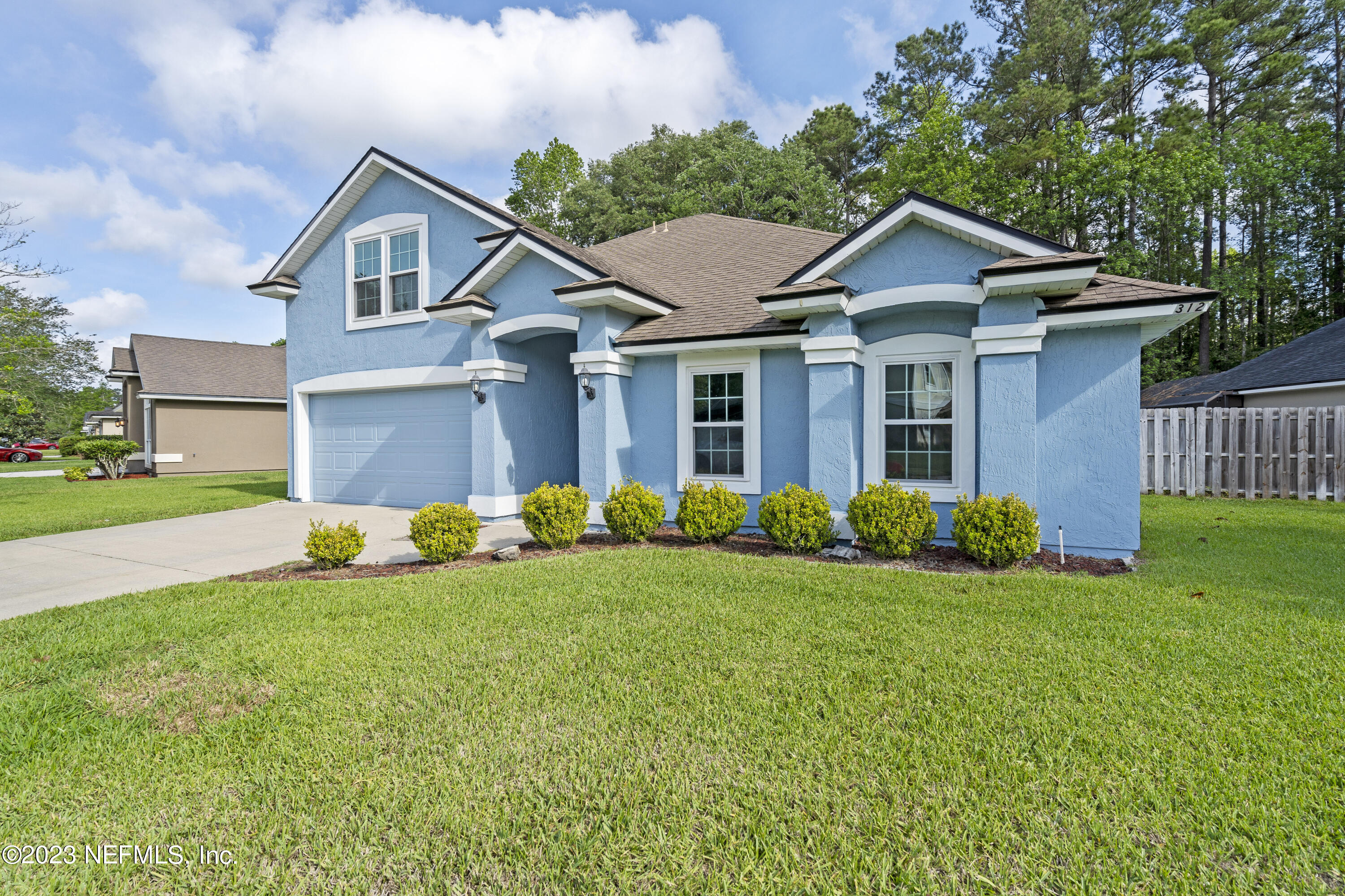 312 West Tropical Trace St. Johns, FL 32259 - Photo 3 of 57 a front view of a house with a yard and garage
