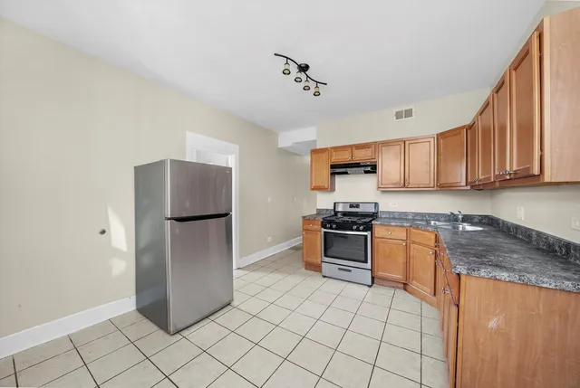 a kitchen with stainless steel appliances granite countertop a refrigerator sink and stove