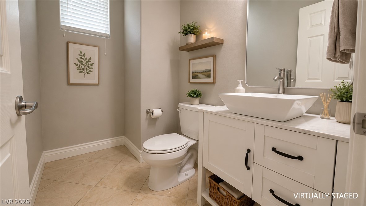 87 Tall Ruff Drive Las Vegas, NV 89148 - Photo 53 of 71 Clean lines define this powder room, featuring a sleek vessel sink and neutral tile flooring.