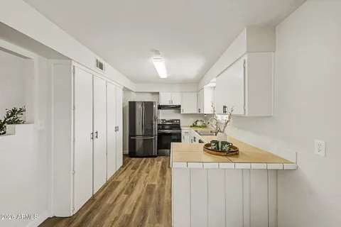 a kitchen with stainless steel appliances a refrigerator a stove a sink dishwasher and wooden cabinets