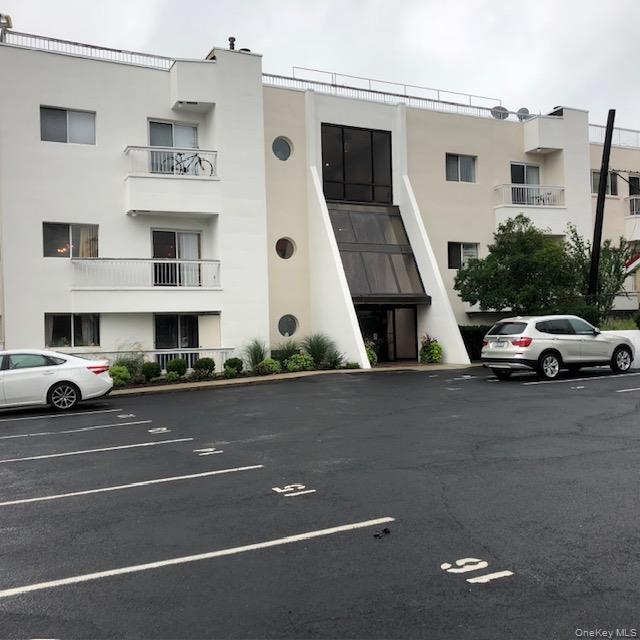 a view of a cars park in front of a building