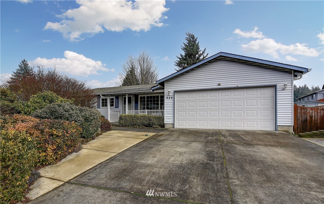 a front view of house with yard and trees around