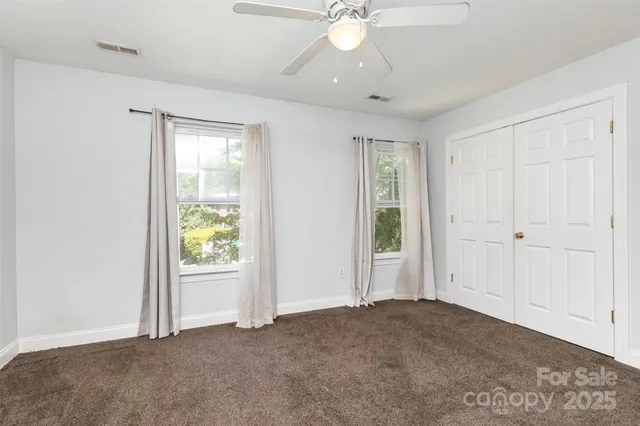 an empty room with fan and windows