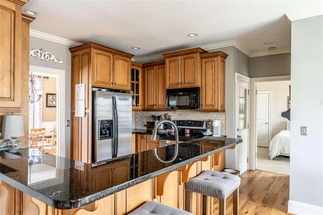 a kitchen with stainless steel appliances granite countertop a refrigerator and a stove top oven