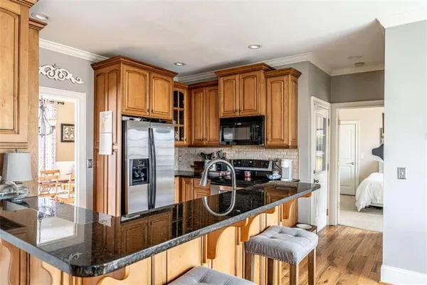 a kitchen with stainless steel appliances granite countertop a refrigerator and a stove top oven