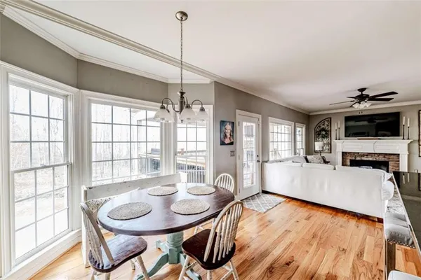a view of a dining room and livingroom with furniture wooden floor a chandelier