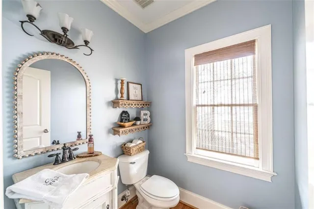 a bathroom with a sink vanity mirror and toilet