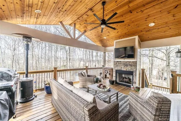 a living room with furniture a flat screen tv and a fireplace