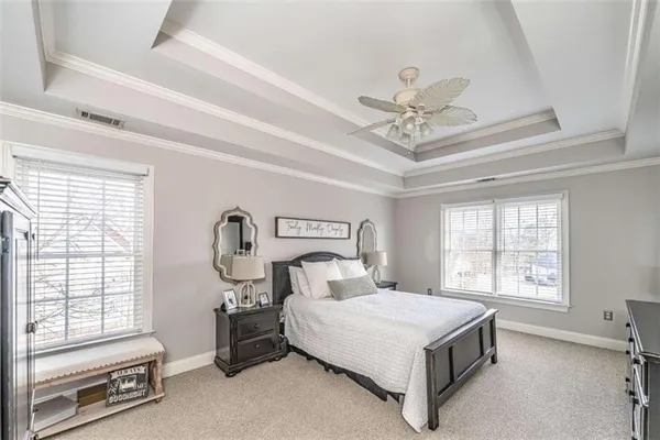 a spacious bedroom with a bed and a chandelier