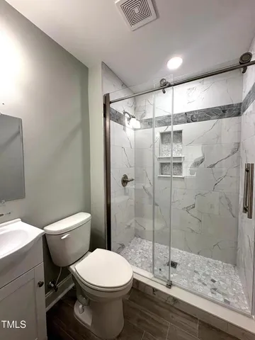 a bathroom with a toilet and a shower
