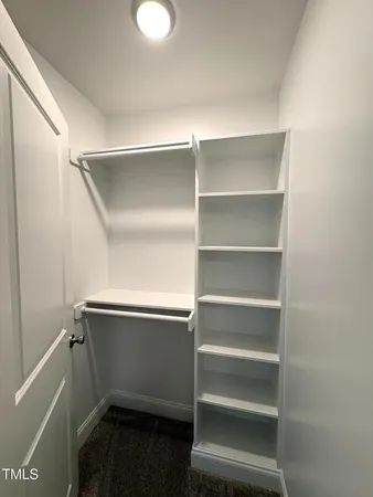 a view of walk in closet with empty racks
