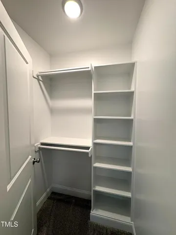 a view of walk in closet with empty racks