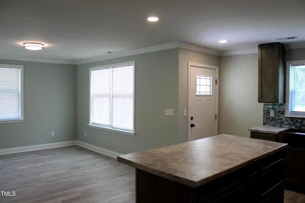 a room with a table chairs and wooden floor