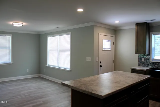 a room with a table chairs and wooden floor