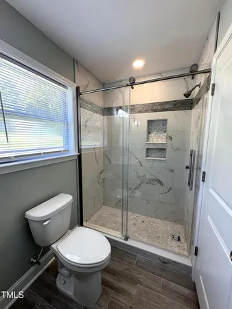 a bathroom with a toilet and a shower