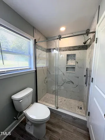 a bathroom with a toilet and a shower