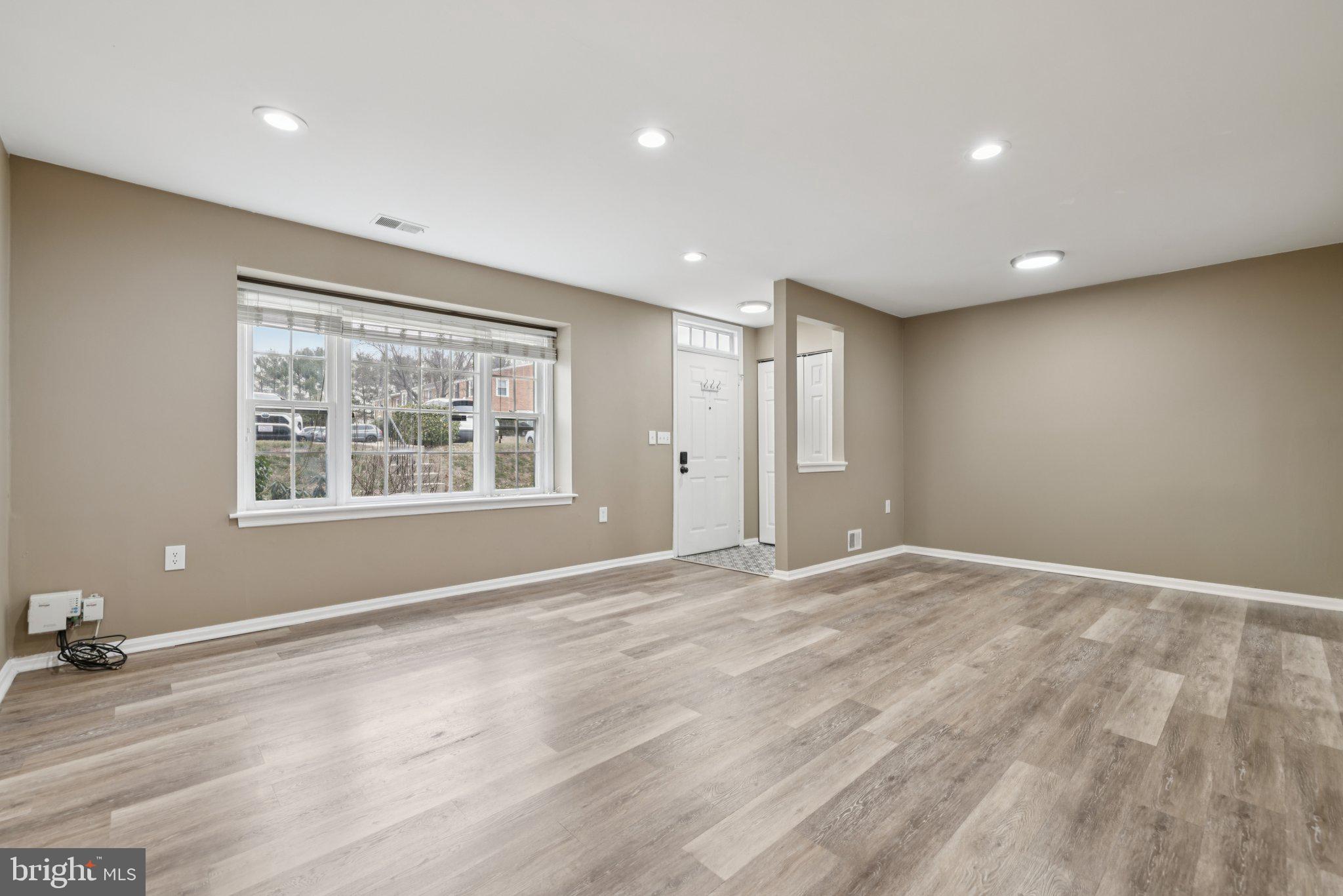 9075 North Laurel Road, Unit E Laurel, MD 20723 - Photo 4 of 20 a view of an empty room with window and wooden floor