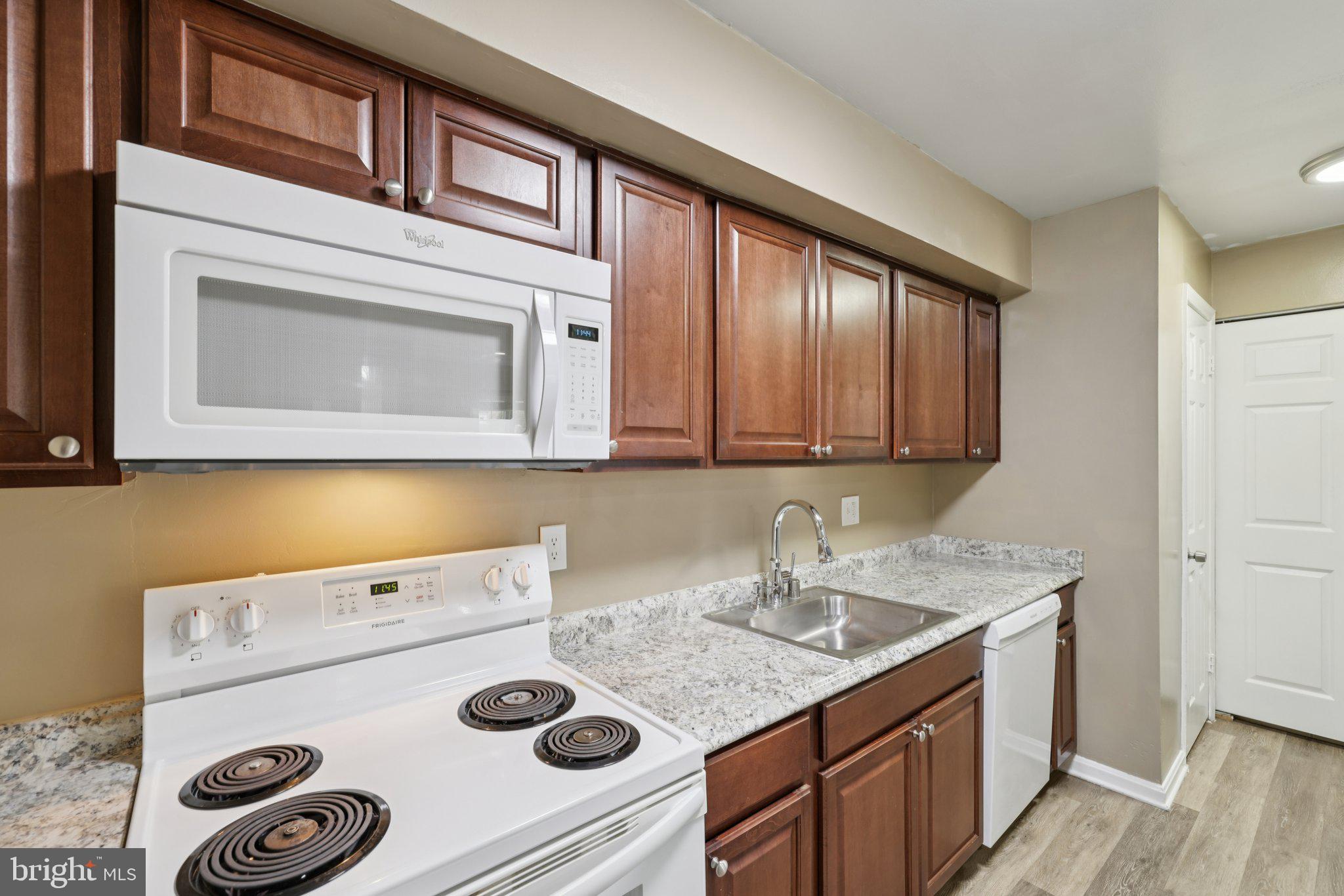 9075 North Laurel Road, Unit E Laurel, MD 20723 - Photo 9 of 20 a kitchen with a sink a stove and cabinets