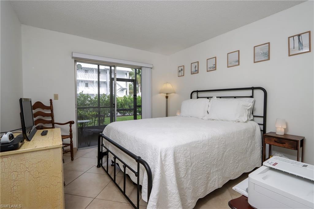 766 Central Avenue, Unit 119 Naples, FL 34102 - Photo 12 of 15 a bedroom with a bed and large windows