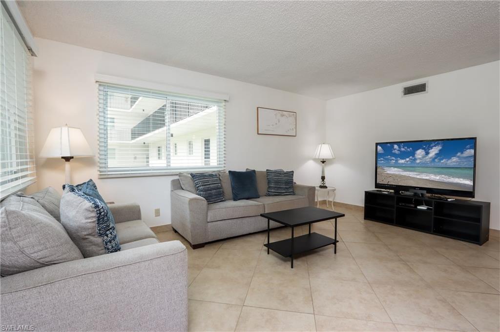 766 Central Avenue, Unit 119 Naples, FL 34102 - Photo 3 of 15 a living room with furniture and a flat screen tv