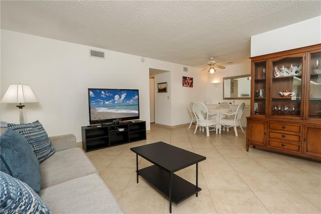 766 Central Avenue, Unit 119 Naples, FL 34102 - Photo 4 of 15 a living room with furniture and a flat screen tv