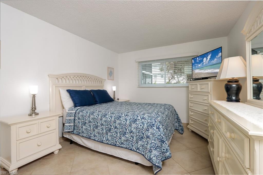 766 Central Avenue, Unit 119 Naples, FL 34102 - Photo 9 of 15 a bedroom with a bed and a dresser