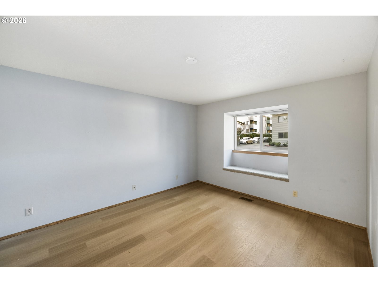 12516 Southeast Stark Street, Unit C Portland, OR 97233 - Photo 30 of 47 an empty room with wooden floor and windows