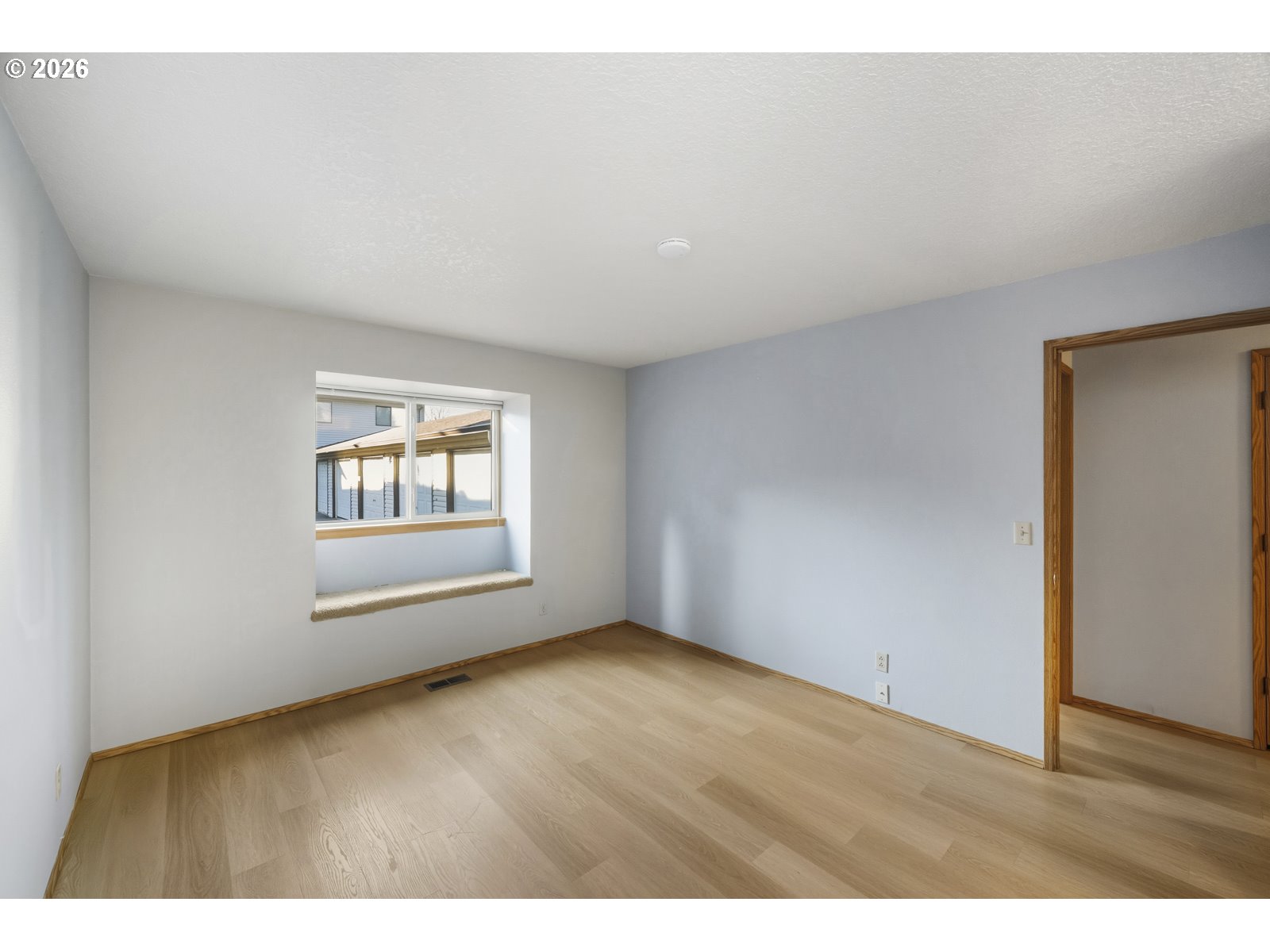 12516 Southeast Stark Street, Unit C Portland, OR 97233 - Photo 33 of 47 a view of an empty room with wooden floor and a window