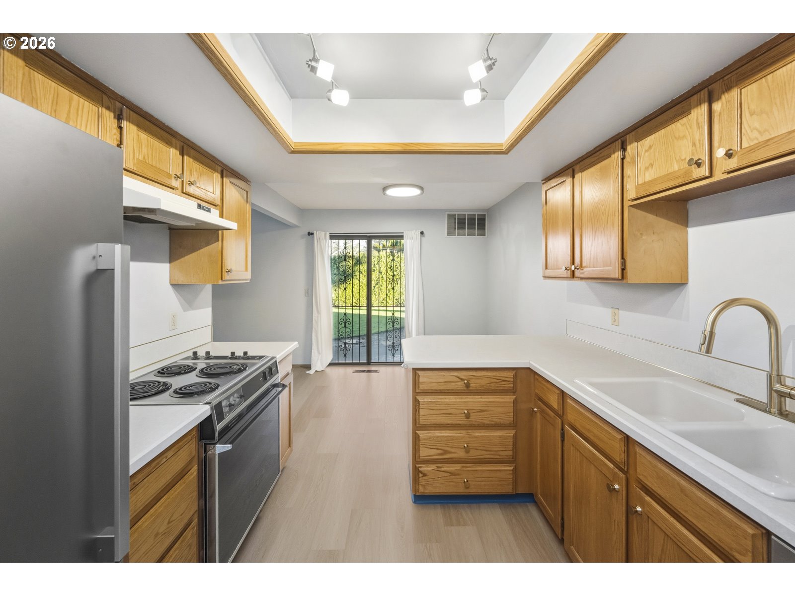 12516 Southeast Stark Street, Unit C Portland, OR 97233 - Photo 4 of 47 a kitchen with stainless steel appliances granite countertop a sink stove and refrigerator