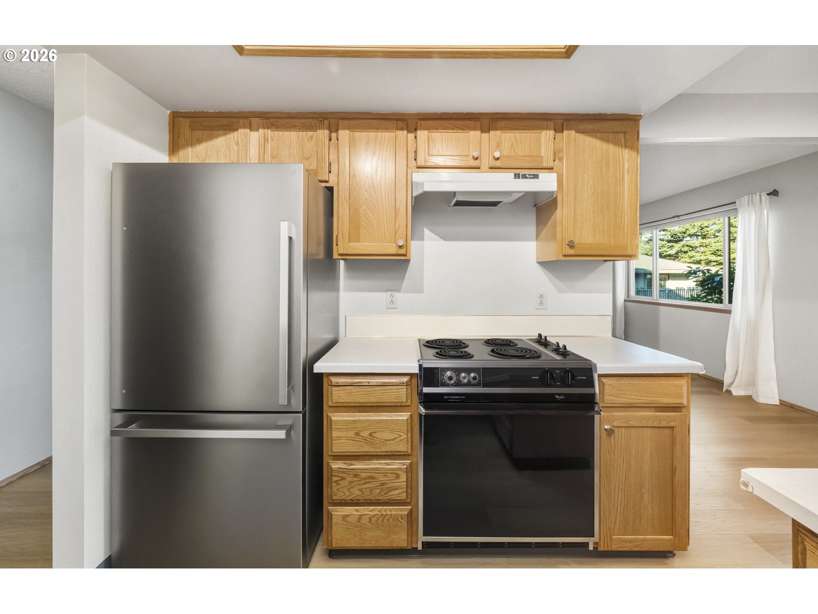 12516 Southeast Stark Street, Unit C Portland, OR 97233 - Photo 5 of 47 a kitchen with a stove and a refrigerator