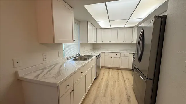a kitchen with a sink a refrigerator and window
