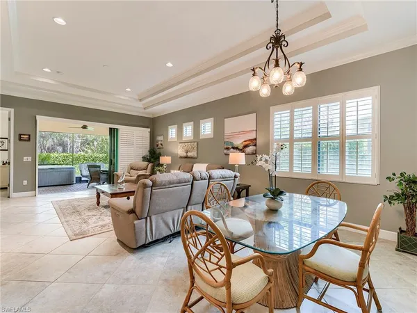 a dining room with furniture a chandelier and window