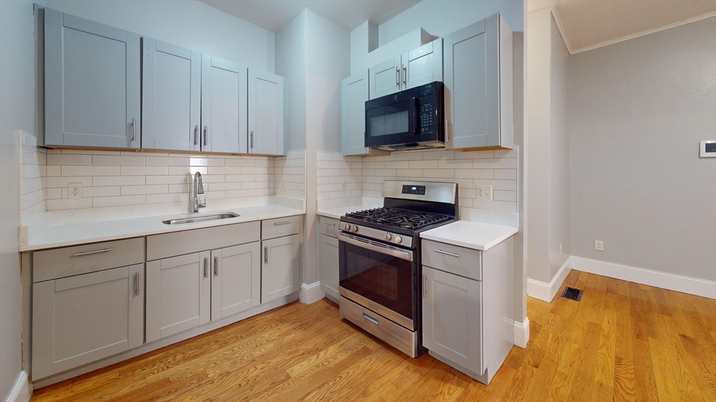 a kitchen with stainless steel appliances granite countertop a stove a sink and a microwave