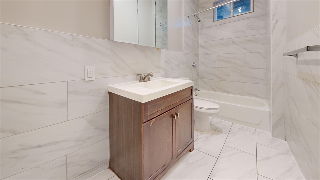 8 Wardman Road, Unit 1 Boston, MA 02119 - Photo 3 of 14 a bathroom with a sink a toilet and shower