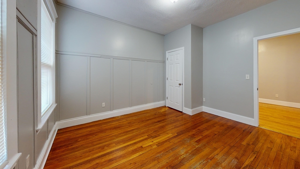 8 Wardman Road, Unit 1 Boston, MA 02119 - Photo 6 of 14 a view of an empty room with wooden floor