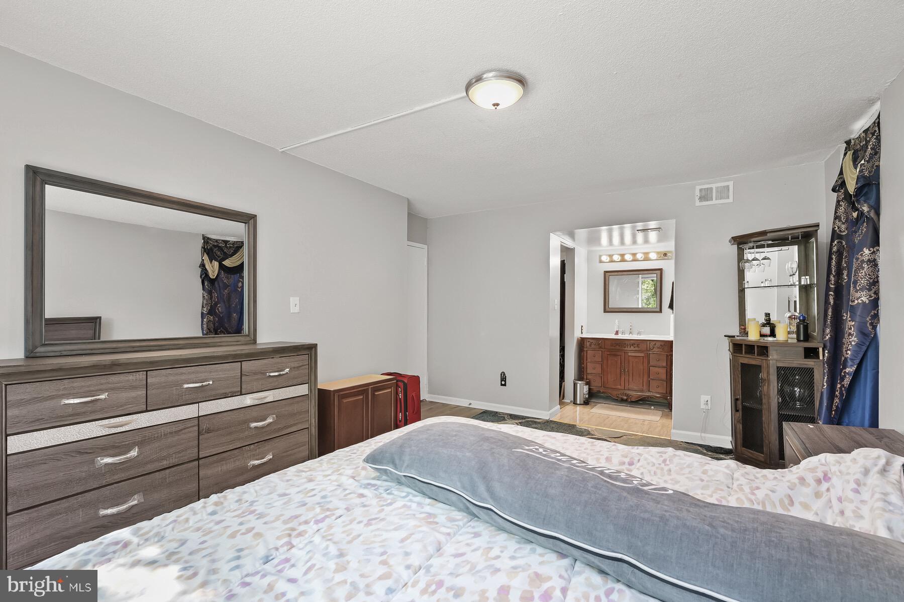 1836 Metzerott Road, Unit G3 Adelphi, MD 20783 - Photo 13 of 19 a bedroom with a bed and a large mirror on dresser