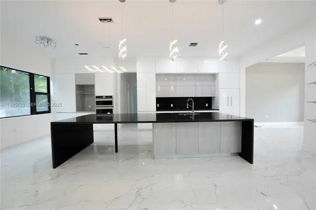 a large living room with stainless steel appliances kitchen island a large counter top and a couch