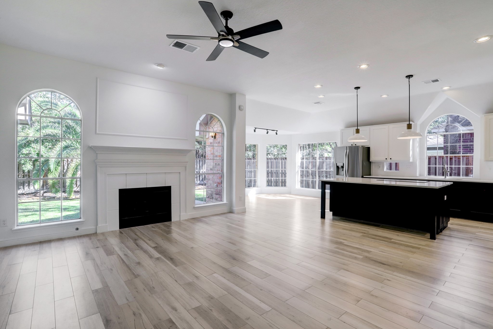 138 Summer Storm Place Spring, TX 77381 - Photo 7 of 20 Spacious family room with a fireplace, arched windows and an open connection to the kitchen and breakfast area.