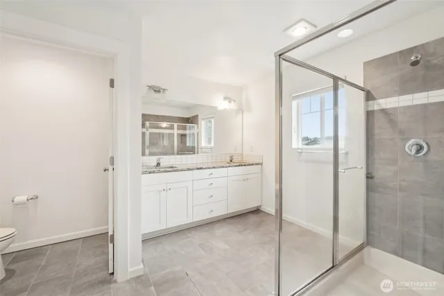 a bathroom with a granite countertop sink mirror and shower