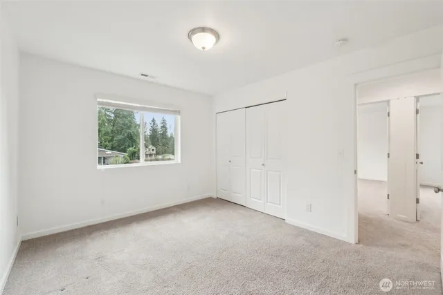 an empty room with windows and closet