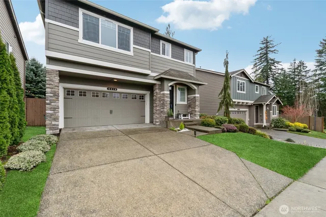 a front view of a house with a yard and garage