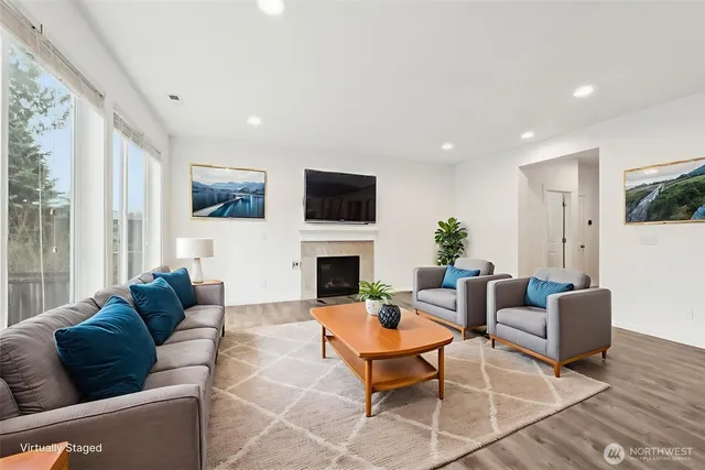 a living room with furniture a fireplace and a flat screen tv
