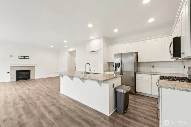 a kitchen with stainless steel appliances kitchen island granite countertop a stove and a refrigerator