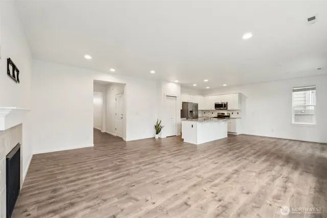 a view of kitchen with kitchen island stainless steel appliances refrigerator sink and cabinets