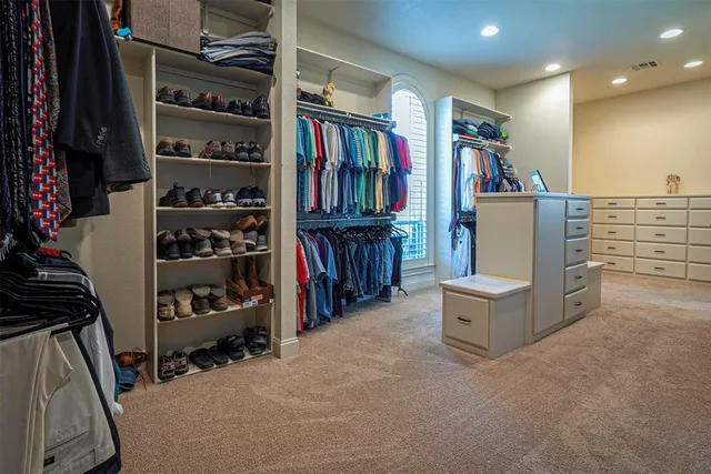 a view of walk in closet with clothes and shoes