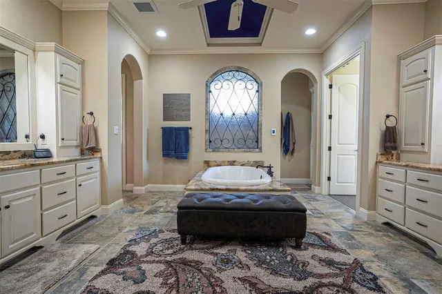 a spacious bedroom with a bed a mirror and dresser