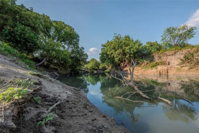 a view of a lake in between two trees
