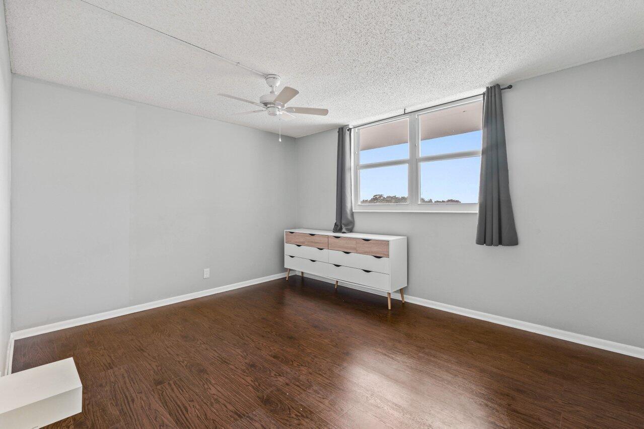 5700 Northwest 2nd Avenue, Unit 401 Boca Raton, FL 33487 - Photo 11 of 30 an empty room with wooden floor and windows