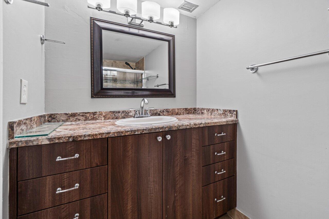 5700 Northwest 2nd Avenue, Unit 401 Boca Raton, FL 33487 - Photo 15 of 30 a bathroom with a granite countertop sink vanity and mirror