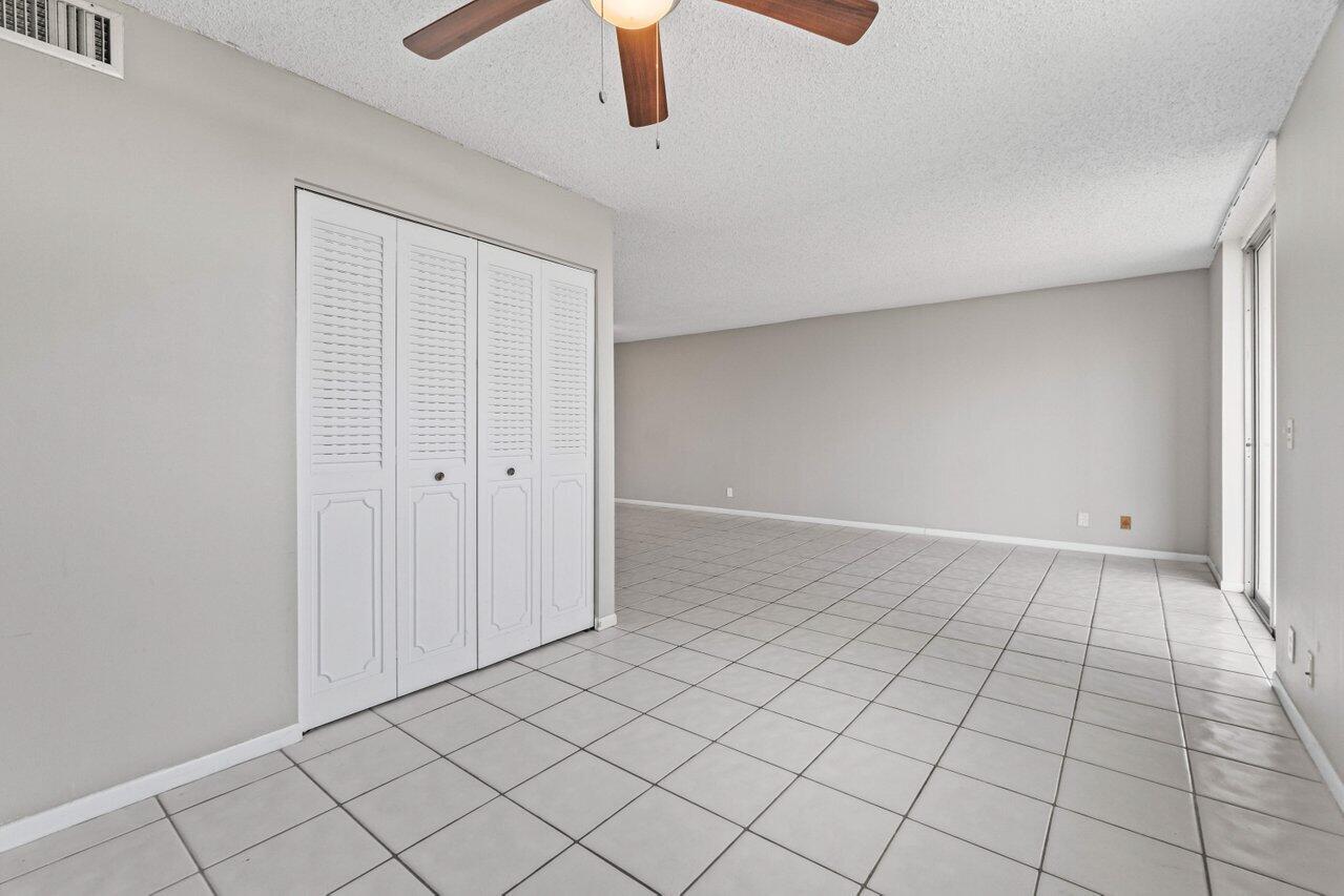 5700 Northwest 2nd Avenue, Unit 401 Boca Raton, FL 33487 - Photo 23 of 30 an empty room with chandelier fan and windows